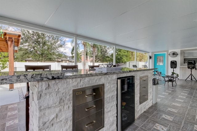 view of patio / terrace featuring beverage cooler, outdoor wet bar, and an outdoor kitchen