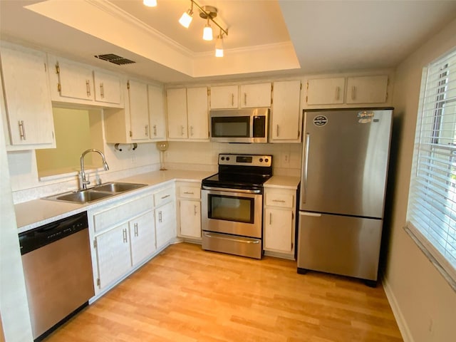 kitchen featuring a sink, a raised ceiling, light countertops, stainless steel appliances, and visible vents