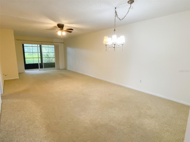 unfurnished room with light colored carpet, baseboards, and ceiling fan with notable chandelier