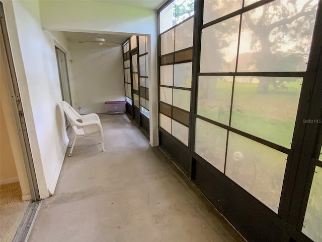 corridor with baseboards and unfinished concrete floors