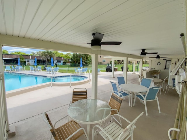 pool with fence, outdoor dining space, and a patio area