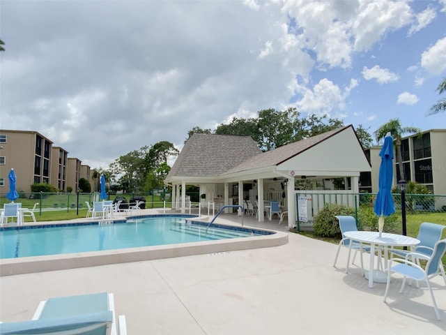 community pool with fence and a patio area