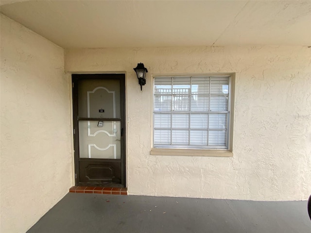 view of exterior entry with stucco siding