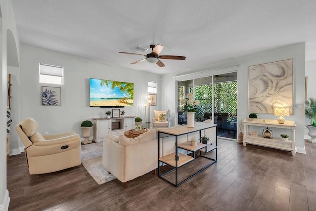 living room featuring dark wood-type flooring, ceiling fan, and baseboards