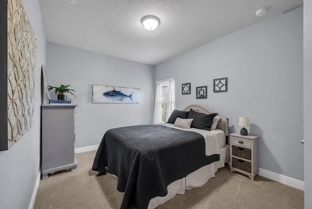 bedroom with carpet floors, a textured ceiling, and baseboards
