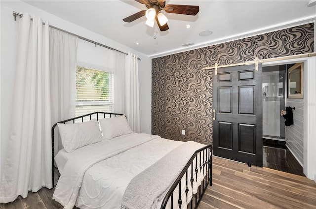 bedroom with a ceiling fan, wood finished floors, and visible vents