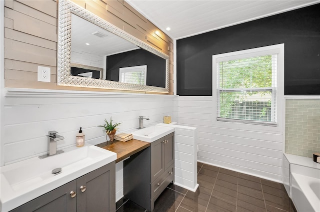 full bathroom with a sink, tile patterned flooring, wood walls, and double vanity