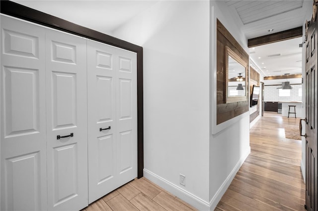 hallway with baseboards and light wood-style flooring