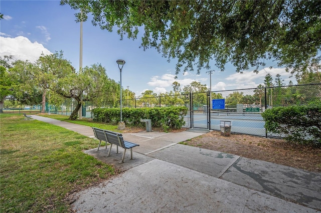 view of home's community featuring a gate, fence, and a yard