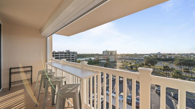 balcony featuring a water view and a city view