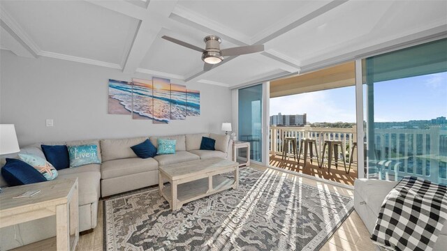 living area with ornamental molding, wood finished floors, beamed ceiling, ceiling fan, and coffered ceiling