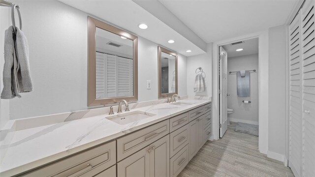 full bathroom with toilet, visible vents, a sink, and a closet