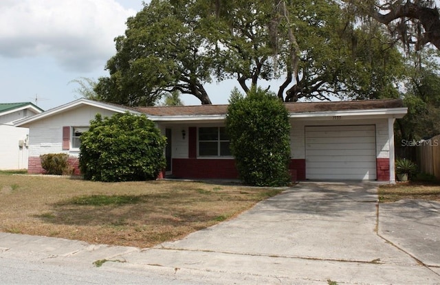 single story home featuring brick siding, driveway, a front yard, and a garage