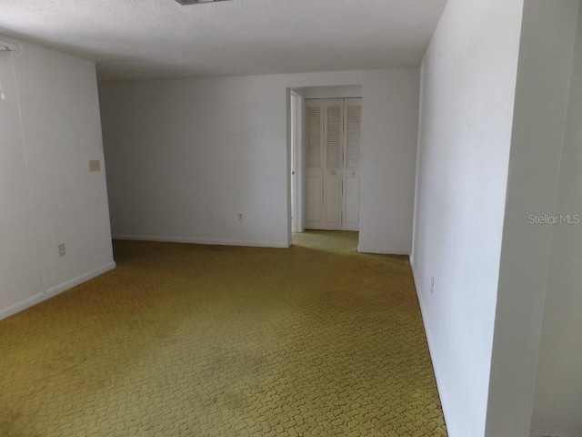 carpeted empty room with baseboards