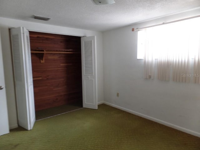 unfurnished bedroom with carpet floors, baseboards, a closet, and a textured ceiling