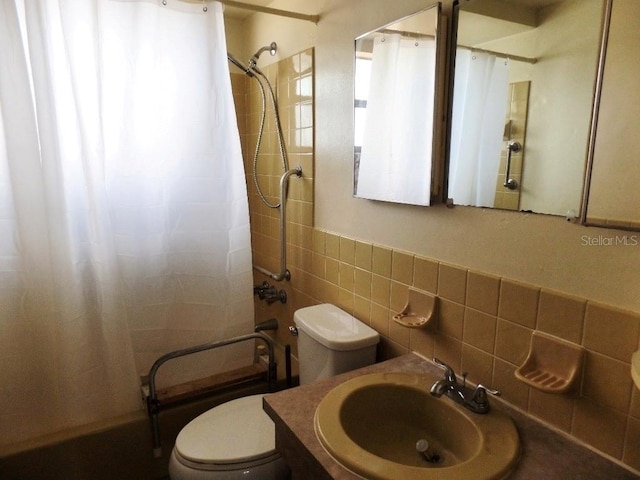 bathroom featuring vanity, toilet, tile walls, and shower / bath combo with shower curtain