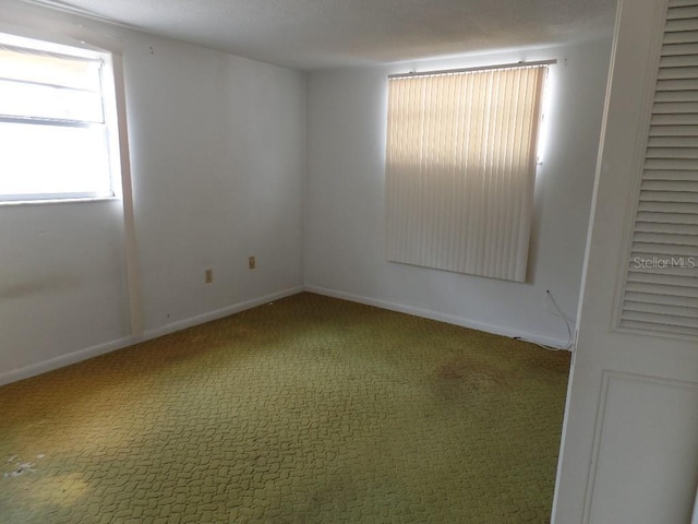 carpeted spare room with baseboards