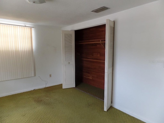 unfurnished bedroom featuring visible vents, a closet, and light carpet