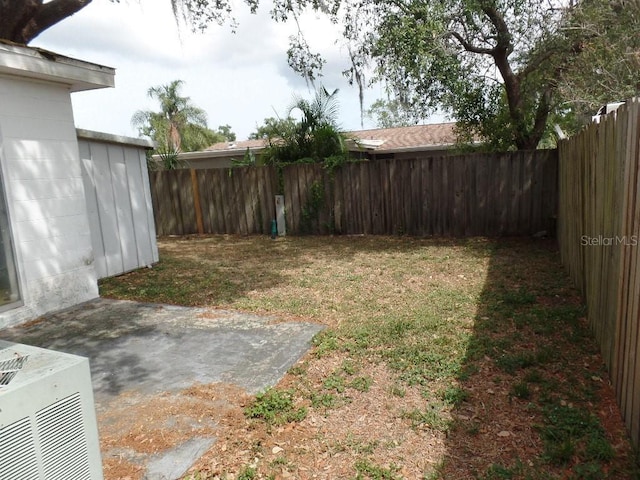 view of yard with central air condition unit, a fenced backyard, and a patio area