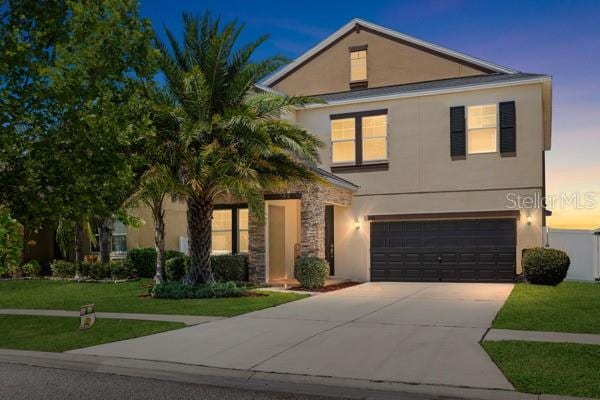11760 Winterset Cove Dr, Riverview, FL 33579 - view of front of house with concrete driveway, an attached garage, a front lawn, and stucco siding