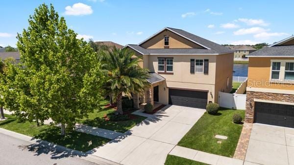 11760 Winterset Cove Dr, Riverview, FL 33579 - view of front of home with driveway, fence, a front lawn, an attached garage, and stucco siding