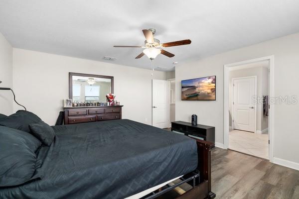 11760 Winterset Cove Dr, Riverview, FL 33579 - bedroom with baseboards, ceiling fan, wood finished floors, and visible vents