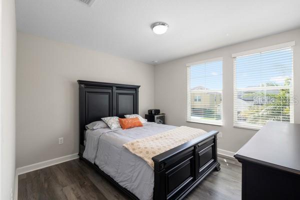 11760 Winterset Cove Dr, Riverview, FL 33579 - bedroom with baseboards and dark wood-style flooring