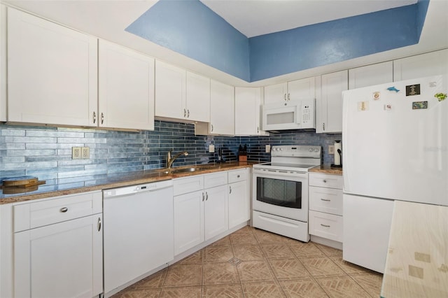 7540 Sunshine Skyway Ln S # 219, Saint Petersburg, FL 33711 - kitchen featuring a sink, tasteful backsplash, white appliances, and white cabinets