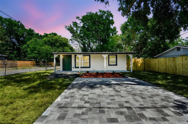 10011 N Annette Ave, Tampa, FL 33612 - view of front of property with covered porch, a lawn, fence, and stucco siding