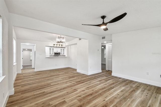 10011 N Annette Ave, Tampa, FL 33612 - spare room featuring a chandelier, ceiling fan, and light wood-type flooring