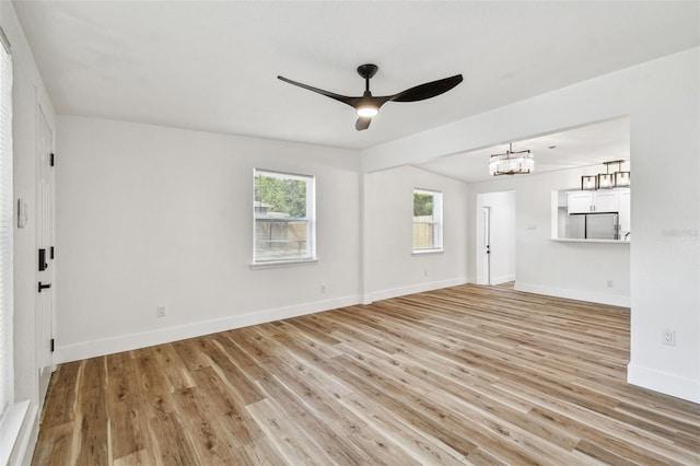 10011 N Annette Ave, Tampa, FL 33612 - empty room with ceiling fan, light wood-style floors, and a chandelier