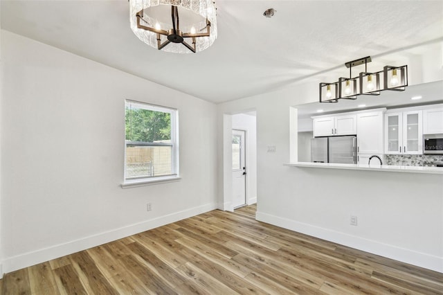 10011 N Annette Ave, Tampa, FL 33612 - unfurnished dining area with a chandelier and wood finished floors