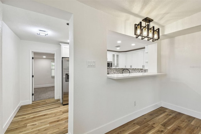 10011 N Annette Ave, Tampa, FL 33612 - corridor with a chandelier, light wood-style flooring, and recessed lighting