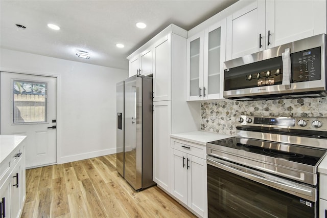 10011 N Annette Ave, Tampa, FL 33612 - kitchen with appliances with stainless steel finishes, light countertops, white cabinets, light wood-type flooring, and recessed lighting