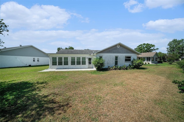back of house featuring stucco siding and a yard