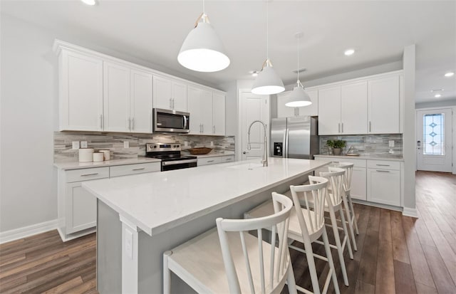 5953 Bluestar Ct, Lakewood Ranch, FL 34211 - kitchen with decorative backsplash, dark wood-style flooring, recessed lighting, a sink, and stainless steel appliances