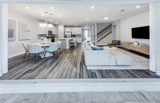 5953 Bluestar Ct, Lakewood Ranch, FL 34211 - living area with ceiling fan with notable chandelier, stairs, recessed lighting, baseboards, and wood finished floors