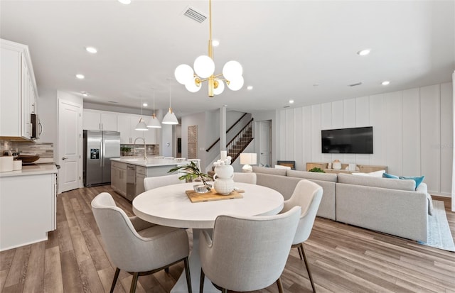 5953 Bluestar Ct, Lakewood Ranch, FL 34211 - dining room featuring an inviting chandelier, recessed lighting, stairs, and wood finished floors