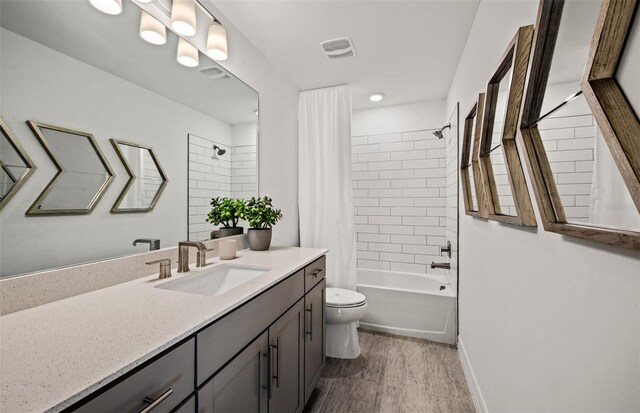 5953 Bluestar Ct, Lakewood Ranch, FL 34211 - bathroom featuring vanity, toilet, shower / bath combo with shower curtain, wood finished floors, and visible vents