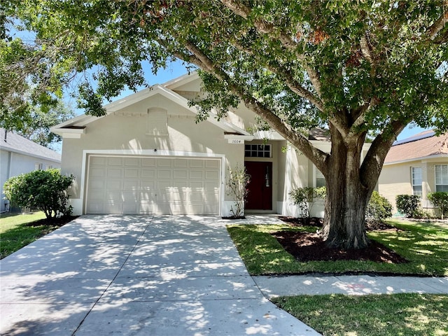 ranch-style home with an attached garage, concrete driveway, and stucco siding