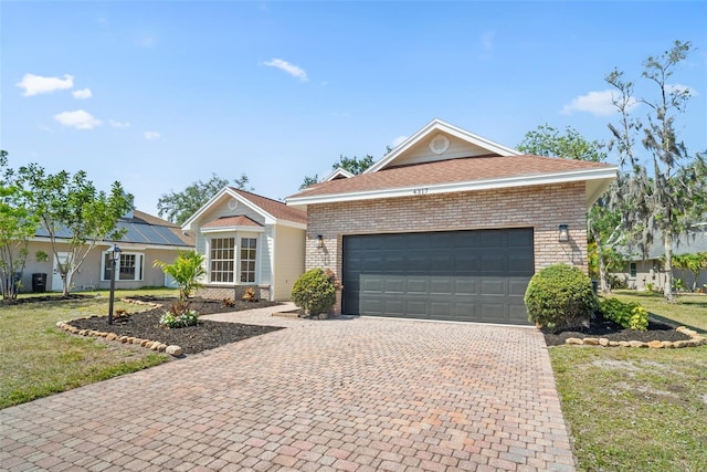 4317 74th Ave E, Sarasota, FL 34243 - view of front of home featuring brick siding, decorative driveway, a garage, and a front yard