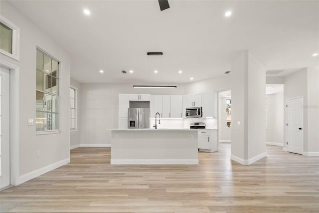 4317 74th Ave E, Sarasota, FL 34243 - kitchen with appliances with stainless steel finishes, white cabinetry, a sink, light countertops, and light wood-style flooring