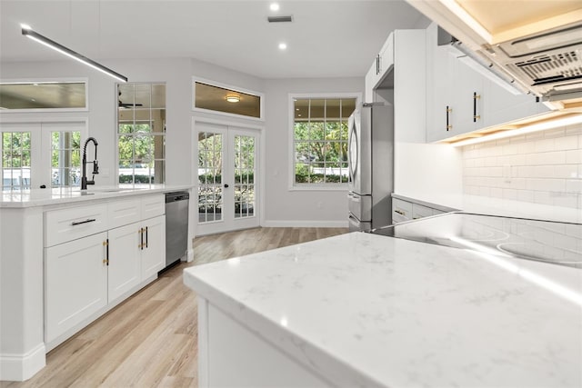 4317 74th Ave E, Sarasota, FL 34243 - kitchen with a sink, appliances with stainless steel finishes, french doors, and light wood finished floors