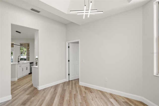 4317 74th Ave E, Sarasota, FL 34243 - spare room with a chandelier, baseboards, visible vents, and light wood-style flooring