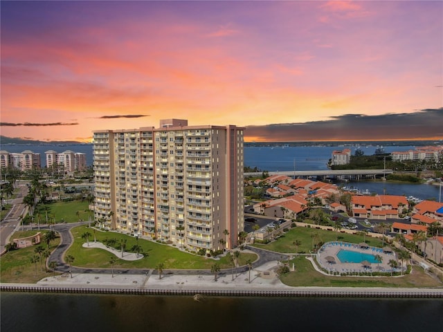 aerial view at dusk featuring a view of city and a water view