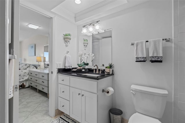 ensuite bathroom featuring toilet, connected bathroom, crown molding, vanity, and a raised ceiling