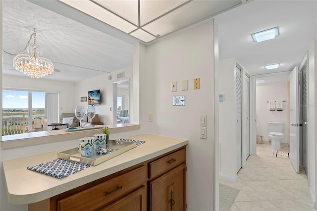 interior space with a notable chandelier, light tile patterned floors, and visible vents