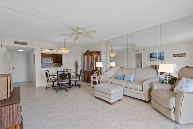 living area with light tile patterned flooring, visible vents, and a ceiling fan