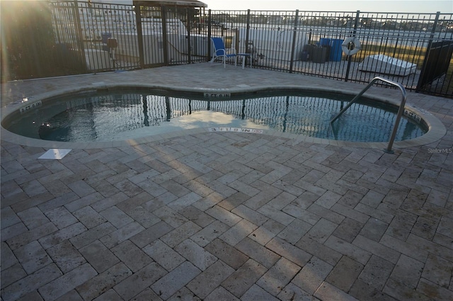 view of pool featuring fence, a swimming pool, and a patio area