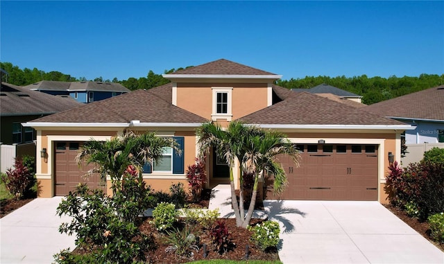 prairie-style house featuring an attached garage, stucco siding, and concrete driveway